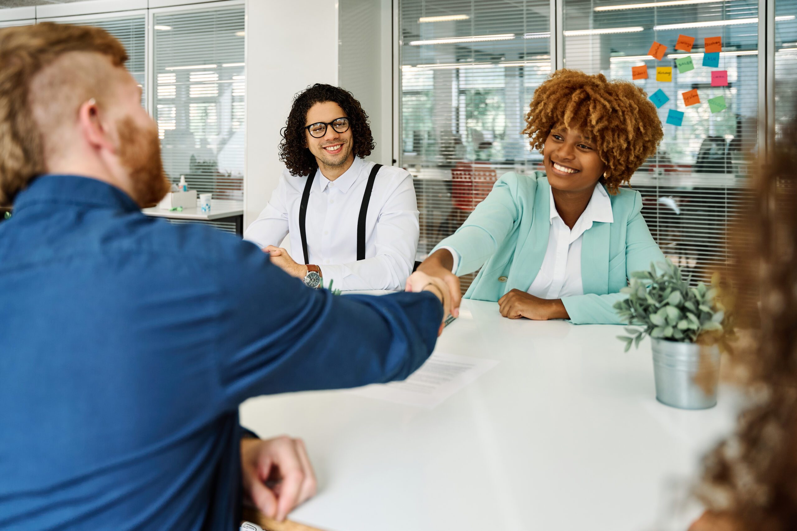 Business professionals smiling during a successful client meeting, highlighting effective customer retention management strategies.
